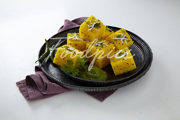 Dhokla Steamed lentil cakes in ornate metalic plate stock photo