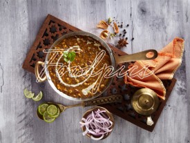 Dal Makhani Black lentil curry & accompaniments in brass vessels image preview