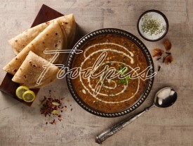 Dal Makhani Lentil curry in ornate bowl with flat breads image preview